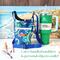 A damask bag with a navy blue and green floral print, is pictured beside a Stanley 40 ounce Quencher, chap stick and a pair of eye glasses.
